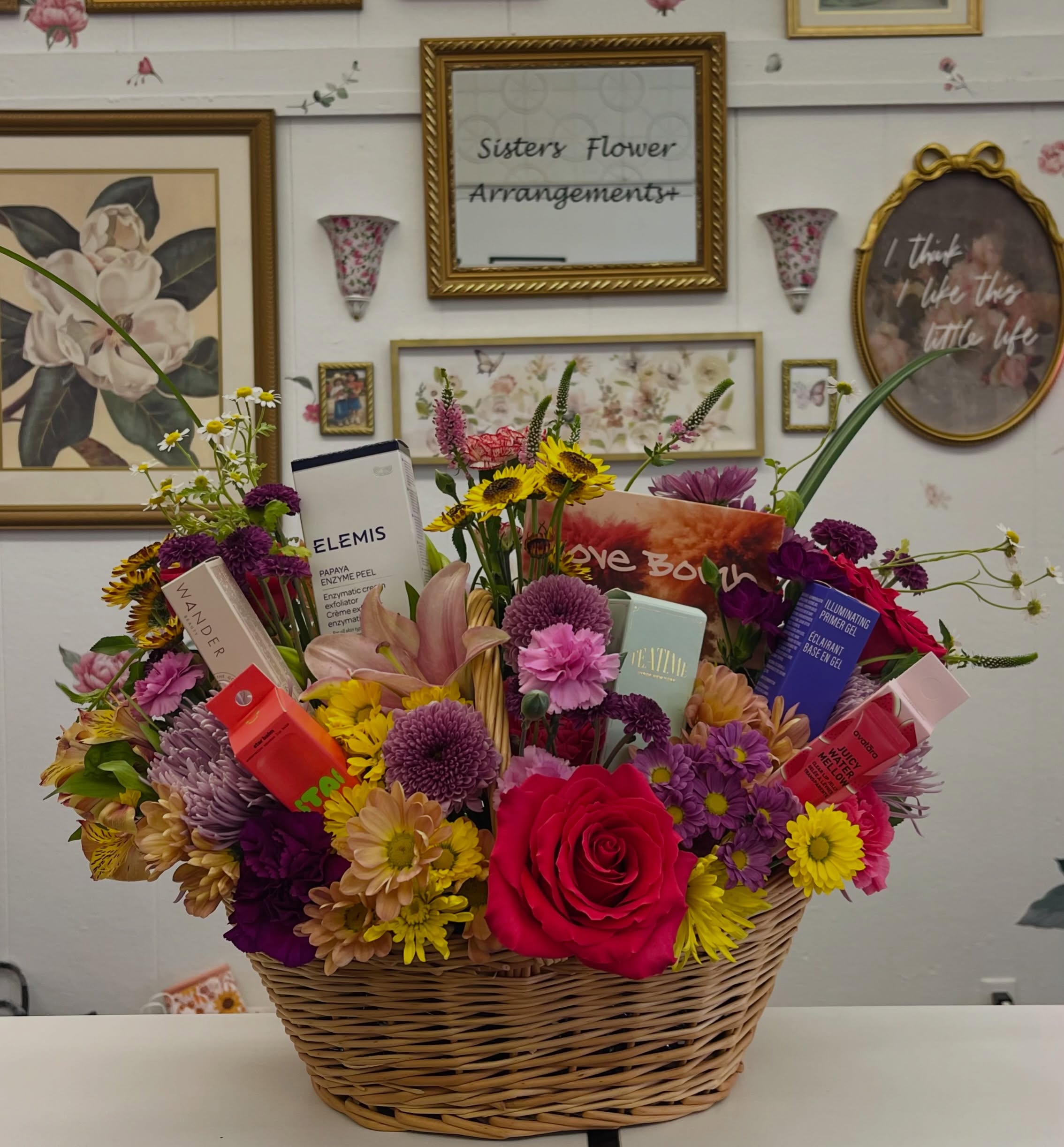 A Sisters Flower Arrangements gift basket with flowers and treats